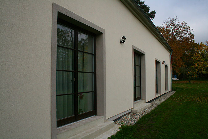 Dřevěná okna na míru propojují hlavní obytný prostor se zahradou.