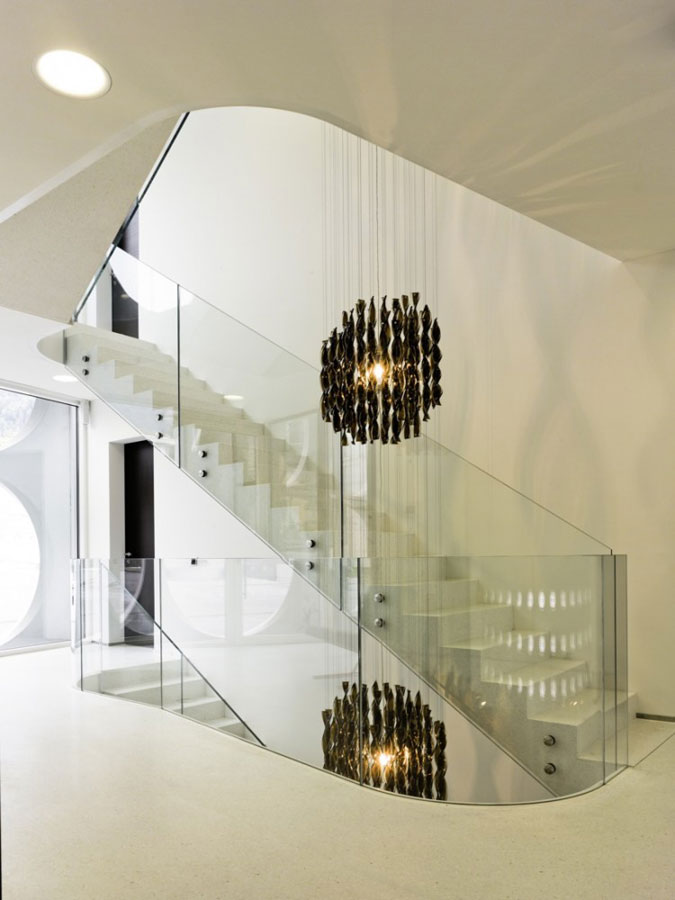 Monolitické betonové schodiště se skleněným zábradlím.